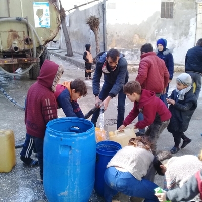 北西部のアレッポで、ユニセフが支援する給水車から水を汲む人たち。(シリア、2023年2月7日撮影)