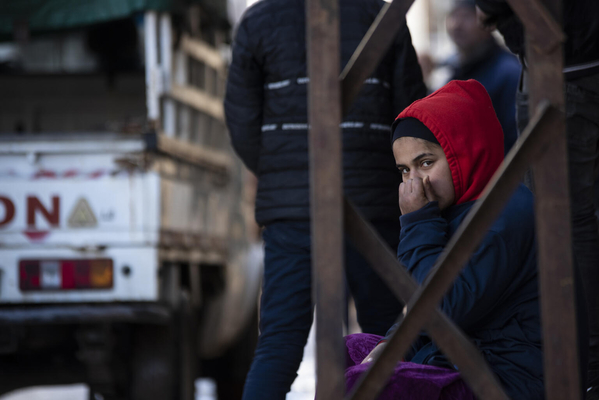 北西部のラタキアで、凍える寒さの中避難し、建物の倒壊を恐れ歩道に座り込む女の子。(シリア、2023年2月7日撮影)