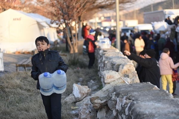 カフラマンマラシュの一時避難所で、水を運ぶ男の子。(トルコ、2023年2月11日撮影)