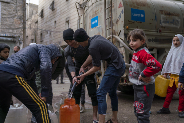 北西部のアレッポで、ユニセフが支援する給水車から安全な水を容器に汲む人たち。(シリア、2023年2月10日撮影)