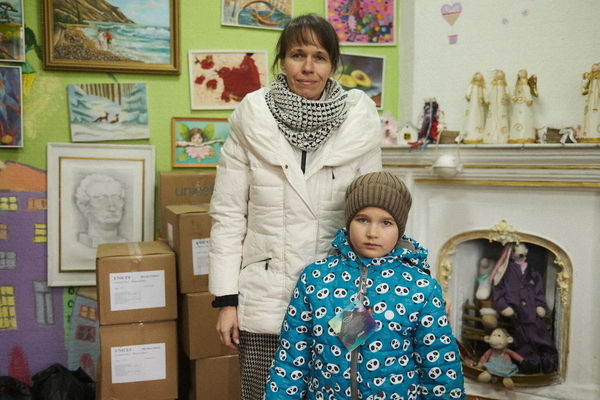 ユニセフの冬の支援物資を受け取り、帽子とダウンを身に着ける7歳のアリアドナさん。価格高騰により子どもたちの服などを買うことができなかった。(ウクライナ、2023年1月13日撮影)