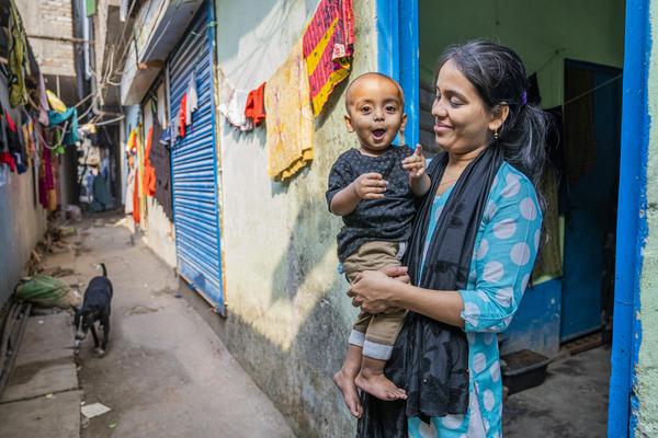 ダッカのスラム街で暮らす1歳のハスナットちゃんと母親。近くにユニセフが支援する診療所ができ、早朝から夜まで、質の高い保健医療を手頃な費用で受けることができる。(バングラデシュ、2022年12月撮影)