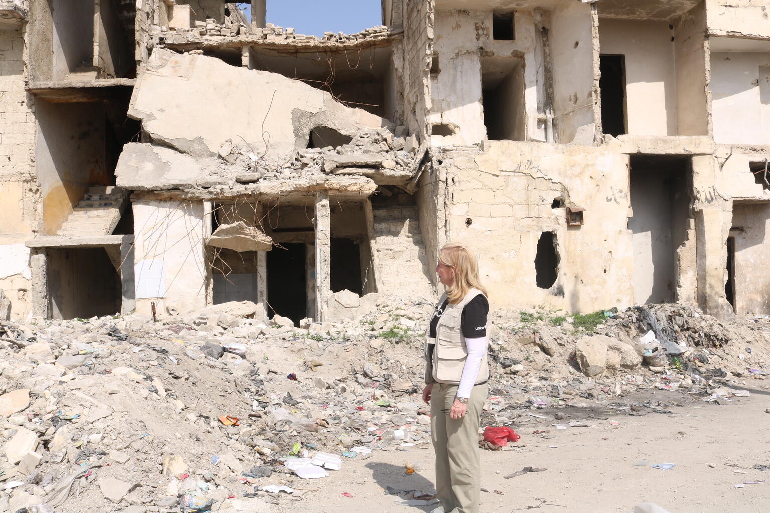アレッポを訪れ、地震によって被害を受けた建物の前に立つ、ユニセフ事務局長のキャサリン・ラッセル。（シリア、2023年3月1日撮影）