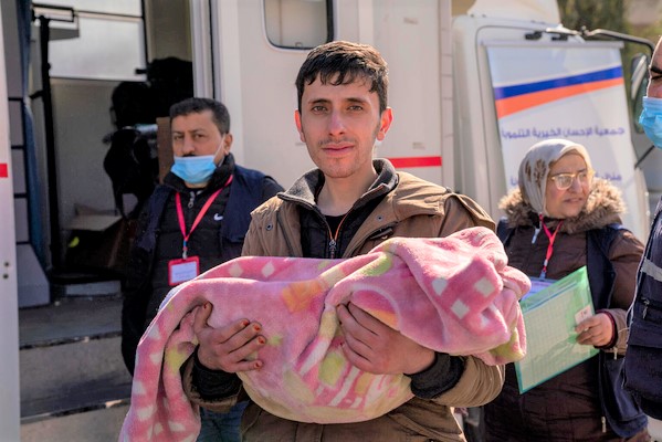 ユニセフの移動式保健クリニックで、栄養状態を診てもらうために子どもを連れてきた父親。(シリア、2023年2月10日撮影)