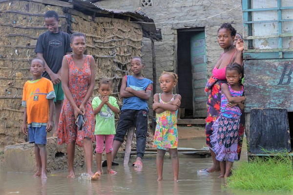 サイクロン「フレディ」により浸水した、ケリマネ近郊の自宅前に立つ家族。母親は、雨による寒さと空腹を訴える子どもたちを避難所へ連れて行くか考えている。(モザンビーク、2023年3月11日撮影)
