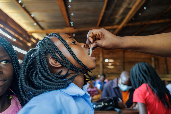 ニアッサ州の小学校で行われたコレラの予防接種キャンペーンで、経口コレラワクチンの投与を受ける女の子。(モザンビーク、2023年2月27日撮影)