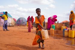 避難民キャンプ内にある給水所から暮らしているテントまで、水タンクを運ぶ10歳の女の子(ソマリア 2022年5月24日撮影)