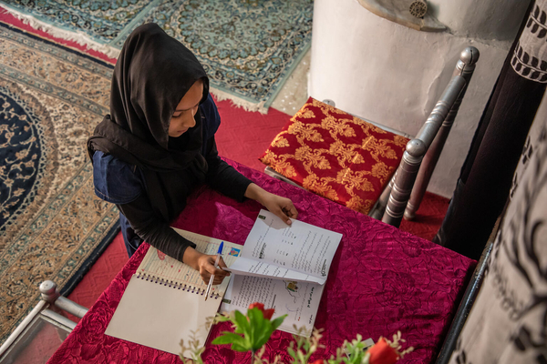 中等教育が禁止されたため、カブールの自宅で、前年度の教科書を使って勉強をする12歳のサマーさん。(アフガニスタン、2023年3月19日撮影)