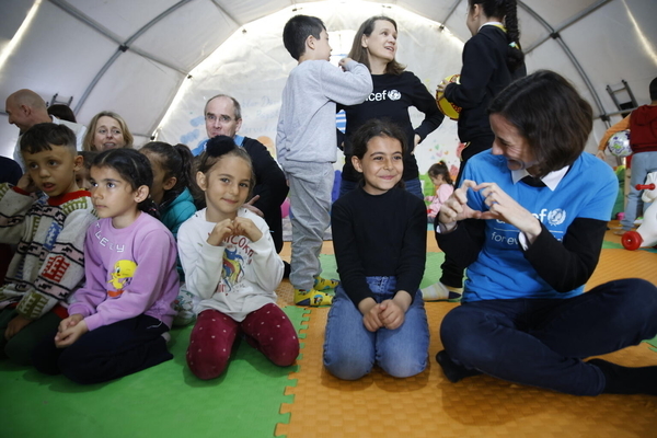 カフラマンマラシュの一時避難所にあるユニセフの子どもにやさしい空間で、ユニセフのスタッフと話す子どもたち。(トルコ、2023年3月16日撮影)