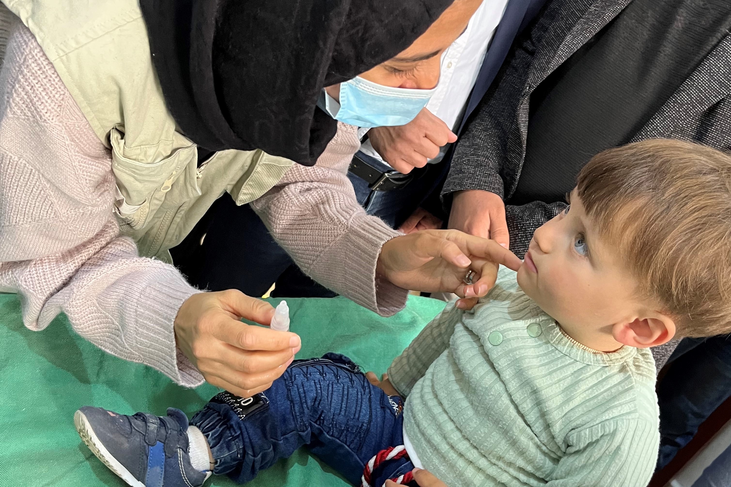 ポリオとはしかの予防接種キャンペーンで、接種前に問診を受けるモハメドちゃん。(シリア)