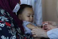 ユニセフの支援で、予防接種を受けるロマ民族の子ども。 ユニセフの移動保健チームによる戸別訪問で、ワクチン未接種であることが確認された2,500人のうちの一人。（コソボ、2022年1月）