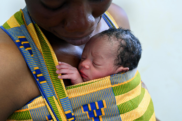 北部のコロゴにある病院で、早産で生まれた赤ちゃんを抱く母親。低体重で生まれた新生児の生存率向上につながるカンガルー・マザー・ケア(KMC)を実践し、生まれたばかりの赤ちゃんを温めている。(コートジボワール、2022年3月撮影)