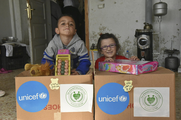 ハマにある避難所で、おもちゃや洋服のユニセフの支援物資を受け取る5歳のアブルドゥルハディちゃんとシャムちゃん。(シリア、2023年3月撮影)