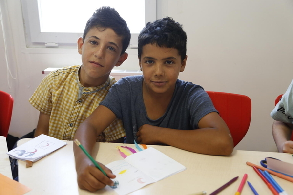 ハタイの一時避難施設にあるユニセフの子どもにやさしい空間で絵を描く男の子たち。(トルコ、2023年5月11日撮影) 