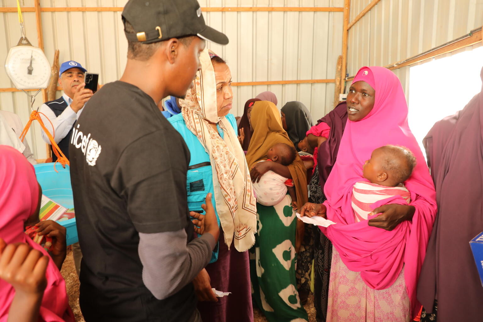 ヒーラーン地方ベレトウェインにある保健施設で、洪水によって避難している家族とはなす、ユニセフ・ソマリア事務所のワファア・サイード代表とスタッフ（ソマリア、2023年5月25日撮影）