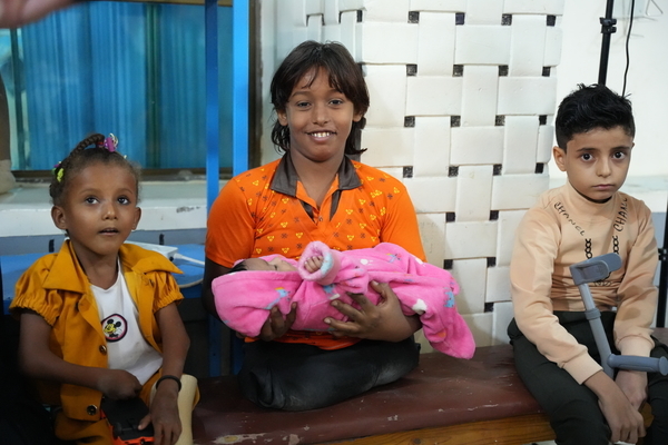 迫撃砲により負傷し、両足を切断したイマドさん(中央)。義肢・理学療法センターで、義足の使い方を学んだり理学療法を受けたりしている。(イエメン、2022年12月撮影)