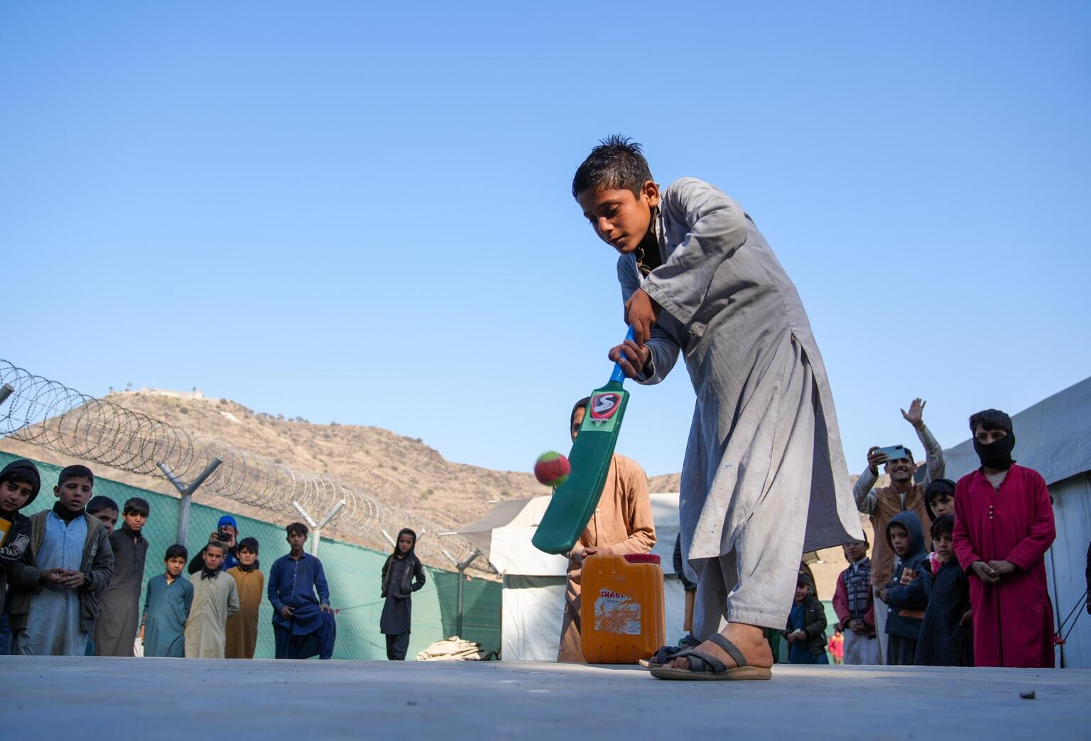 トールハム国境に設置されている、ユニセフが支援する子どもにやさしい空間で、クリケットをするサルマン（アフガニスタン、2022年12月13日撮影）