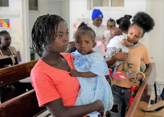 ユニセフの支援で、すぐに食べられる栄養治療食を受け取り、栄養不良から回復した子ども。しかし人々を取り巻く状況は悪く、この親子も経済的支援や栄養支援をまだ必要としている。(ハイチ、2023年5月10日撮影)
