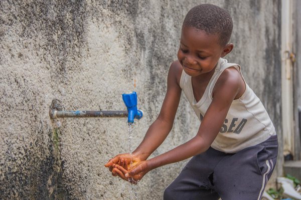 ツォポ州の病院で、ユニセフが設置した水道で手を洗う8歳のエリティエさん。(コンゴ民主共和国、2022年7月撮影)