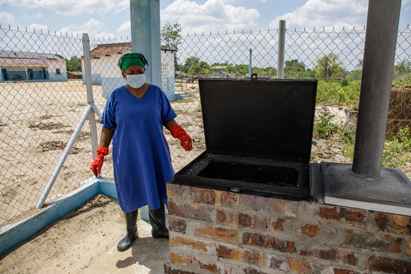ナンプラ州のモナポにある保健センターの焼却炉のそばに立つ、病院の廃棄物責任者。新しくできた焼却炉はフェンスで囲まれ、安全な場所に設置されていて、他の人は出入りできないようになっている。(モザンビーク、2022年11月撮影)