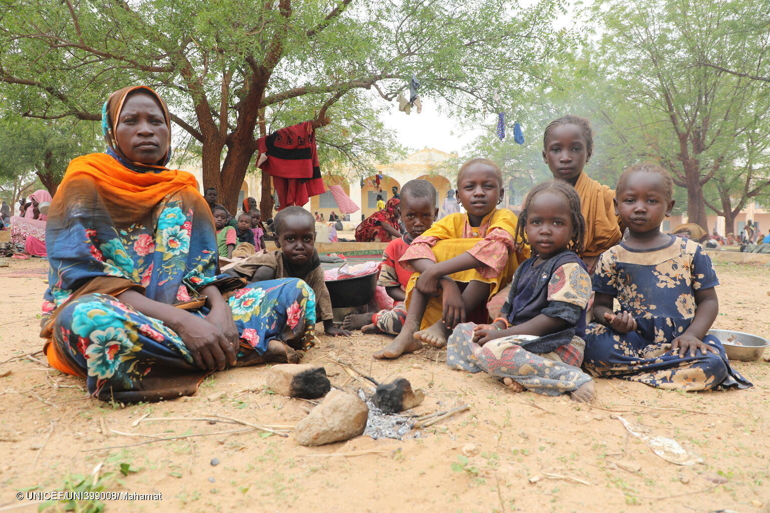 戦闘から逃れるため、スーダン・西ダルフール州の自宅から避難している途中で、6人の子どもたちとはぐれてしまった母親と7歳のイスラちゃん(左2人目)。同じく、避難途中に家族とはぐれてしまった5人の子どもたちを連れて、チャドのアドレに到着し、木陰で休んでいる。(チャド、2023年6月17日撮影)