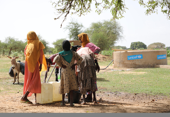 スーダンと国境を接するKoufrounの村で、ユニセフが設置した給水所から水を汲む子どもと女性。(チャド、2023年6月16日撮影)