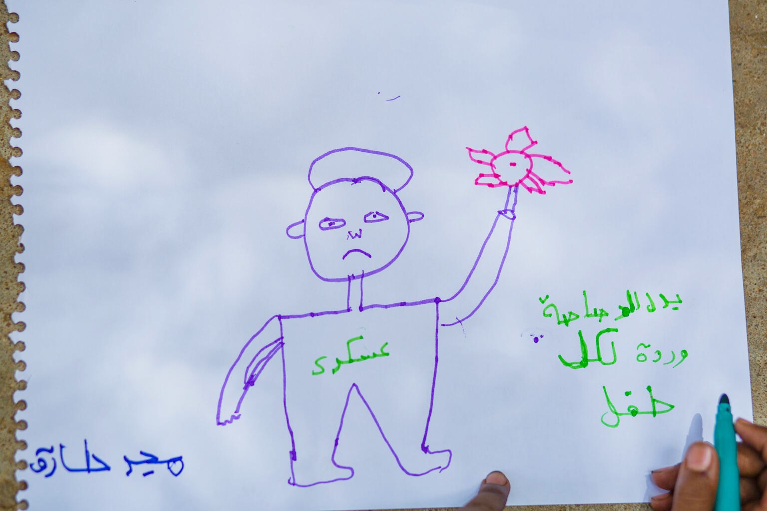 マジュドが描いた、バラの花でふさがれた銃を持つ兵士の絵（スーダン、2023年6月3日撮影）