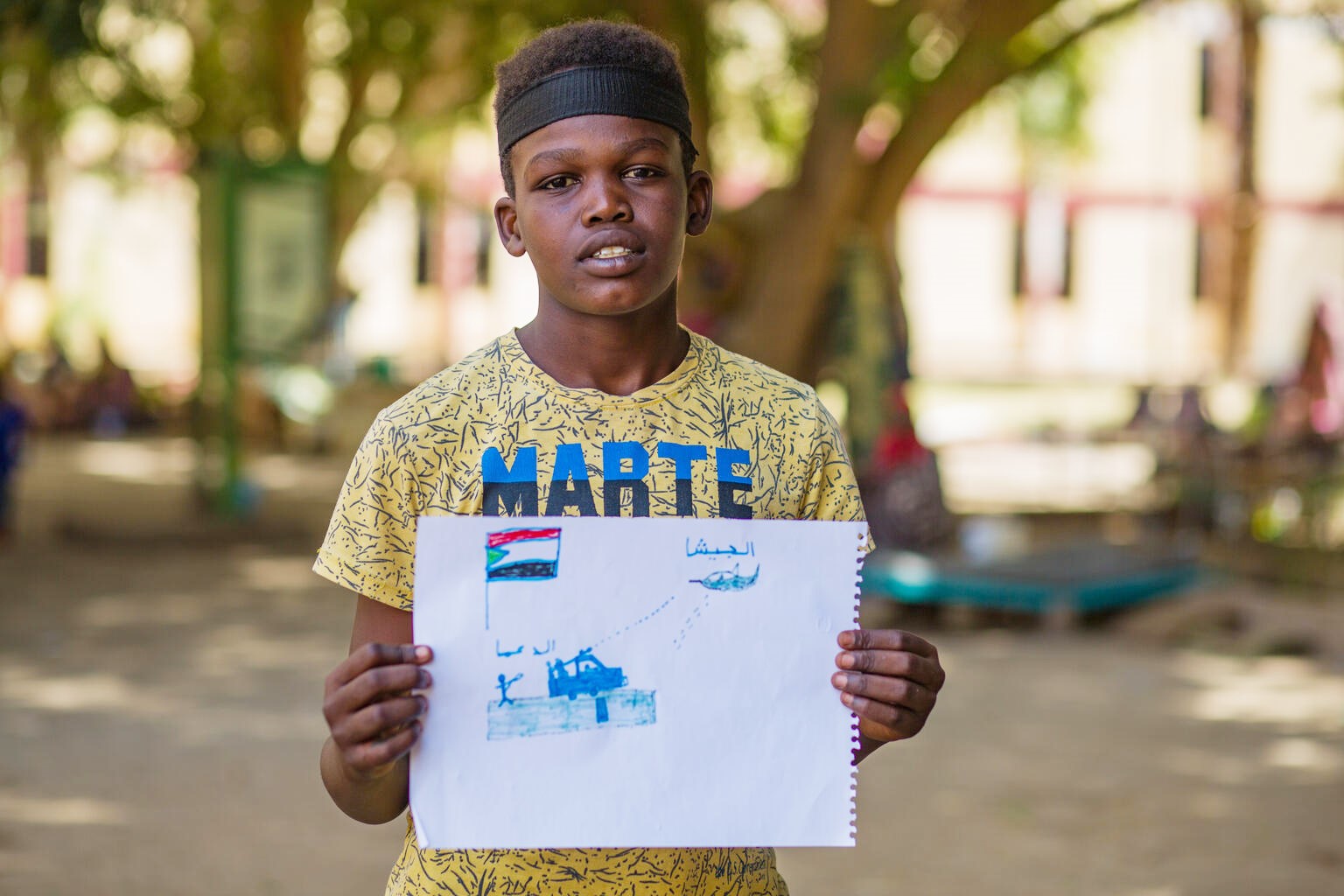 描いた絵を持つアフメド（スーダン、2023年6月3日撮影）