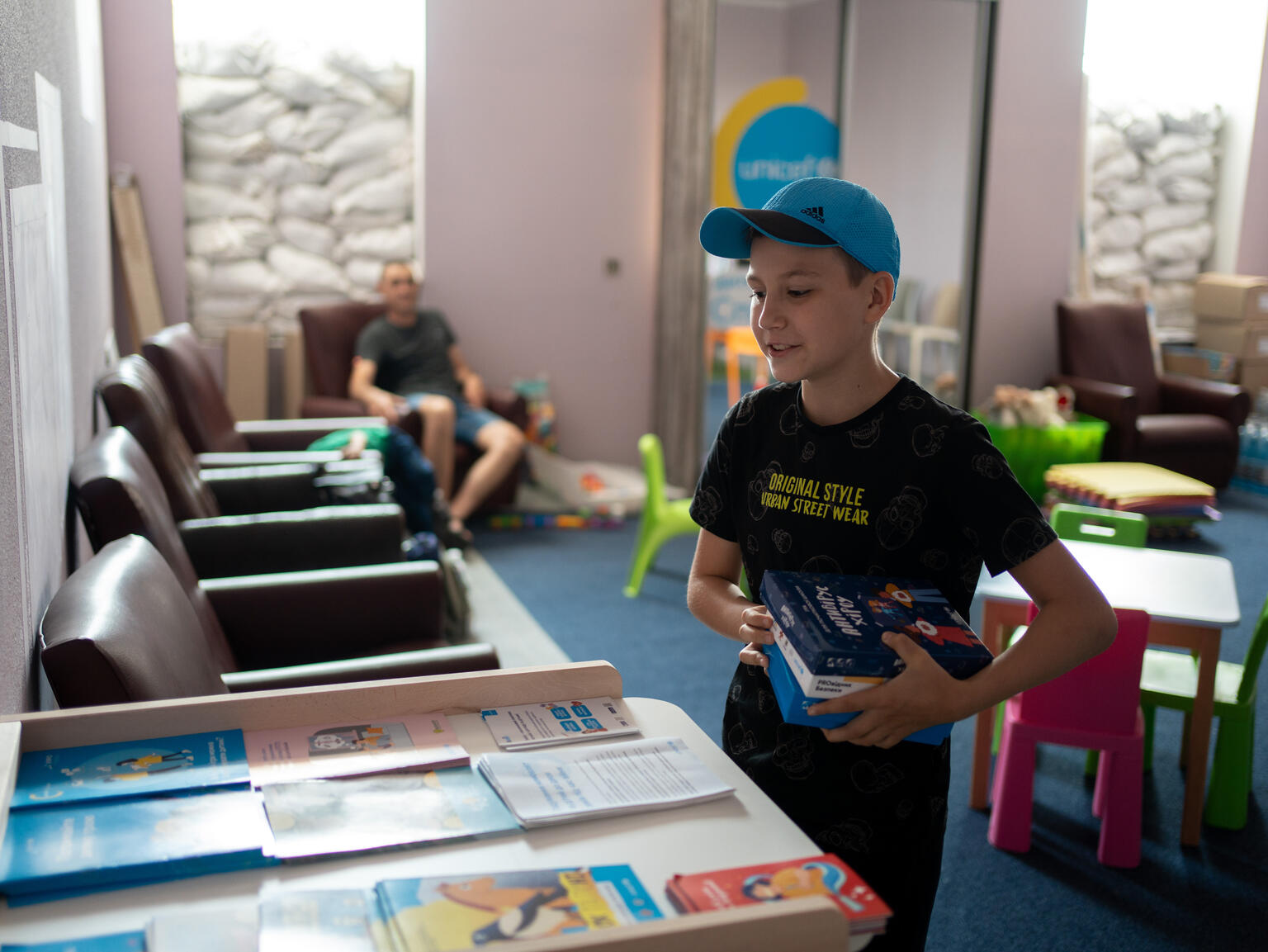 「スピルノ・チャイルド・スポット」にあるパズルなどのおもちゃを手にするイリヤ。（ウクライナ、2023年6月撮影）