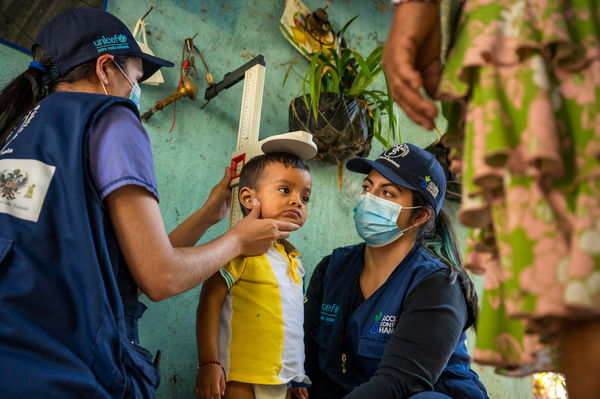 ユニセフが支援する移動式保健・栄養チームのスタッフに身長を測ってもらう2歳のハイメちゃん。移動式保健・栄養チームは遠隔地の村を訪れ、子どもたちの栄養状態の確認や予防接種のサービスを提供している。(グアテマラ、2023年1月撮影)