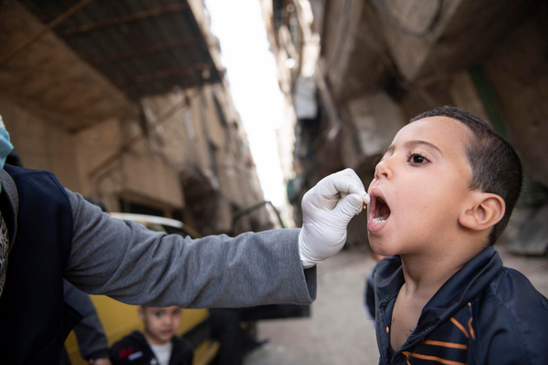 全国予防接種キャンペーンの一環で、ユニセフが支援する移動式保健チームのスタッフからポリオ予防接種の投与を受ける男の子。(シリア、2023年5月撮影) 