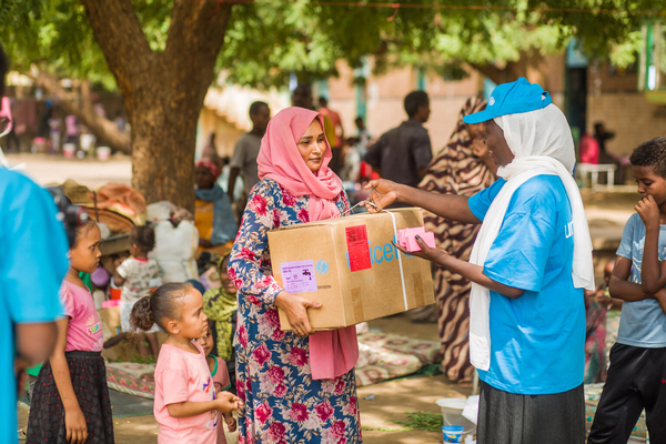 ワドメダニでユニセフのスタッフから衛生キットを受け取る10歳のラハフちゃんと母親。(スーダン、2023年7月18日撮影)