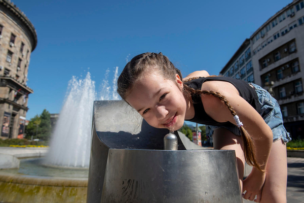 熱中症にならないよう、水を飲む11歳のミリツァさん。(セルビア、2022年7月撮影)