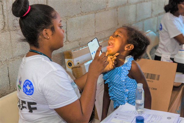 ポルトープランスの国内避難民キャンプで、健康状態のチェックを受ける女の子。武装勢力の暴力により、このキャンプには500人以上の人が避難しており、その半数近くが子どもたちである。(ハイチ、2023年6月撮影)