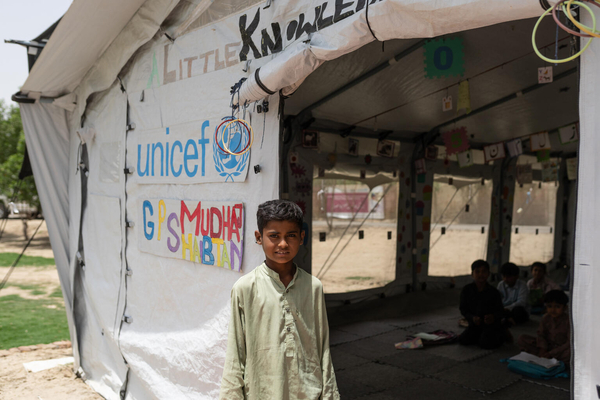 ユニセフの臨時学習センターの前に立つ9歳のムハマッドさん。未だに多くの地域で浸水状態が続いているパキスタンでは、今年の雨季にさらなる熱波が予想されており、多くの子どもたちが気候危機にさらされている。(パキスタン、2023年5月撮影)