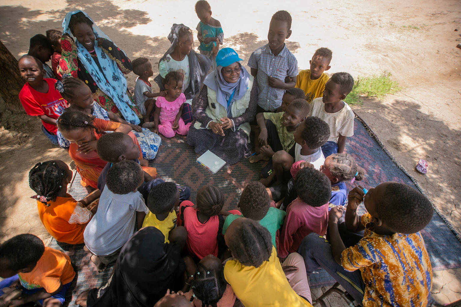 ユニセフのスタッフから心理社会的支援を受ける国内避難民の子どもたち。(スーダン、2023年8月7日撮影)