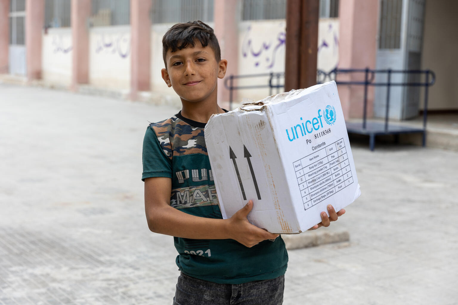 シリア・アレッポにある、避難所となっている学校で、ユニセフから配布された家庭用衛生キットを受け取ったアベッド（10歳）。（シリア、2023年6月14日撮影）