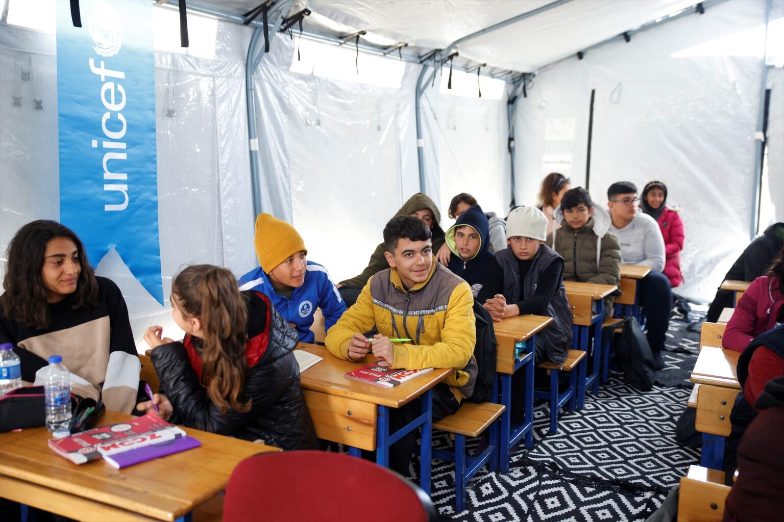トルコ南東部を襲った2度の大地震の後、アンタキヤの仮設避難所にユニセフ設置したテント教室で、授業を受ける子どもたち。（トルコ、2023年3月10日撮影）
