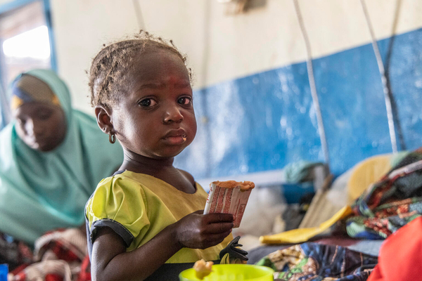 病院の集中栄養回復センターで、すぐに食べられる栄養治療食(RUTF)を口にする2歳のアミラちゃん。(ニジェール、2023年3月撮影)