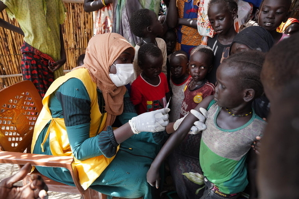 避難民キャンプで、はしかの予防接種を受ける子ども。病気が蔓延しやすい環境に置かれた子どもたちを守るため、ユニセフはスーダン全土で予防接種を行っている。(スーダン、2023年7月25日撮影)