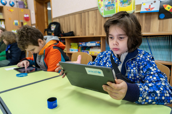 ヘルソン州の学校で、タブレット端末を使用し、授業を受ける8歳のフリブさん。今までは2人の兄弟と1台のスマートフォンを共有して勉強していたが、ユニセフの支援により1台のタブレット端末を受け取ることができた。(ウクライナ、2023年4月撮影)