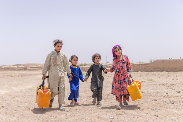 バドギース州の村の中心部にある、ユニセフが支援した水道に水を汲みに行く子どもたち。(アフガニスタン、2023年7月撮影)