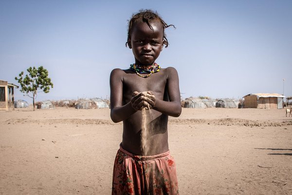 南部諸民族州(SNNP)にある村で、干ばつにより乾いた砂を手に取る子ども。(エチオピア、2023年7月撮影)