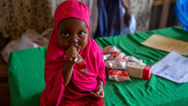 すぐに食べられる栄養治療食を口にする女の子。ユニセフは、干ばつの影響を受ける地域に水や保健、栄養などの緊急支援を提供している。(ソマリア、2023年6月撮影)