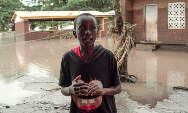 サイクロン「フレディ」により浸水した学校の前に立つ12歳のイブラヒムさん。(マラウイ、2023年3月撮影)