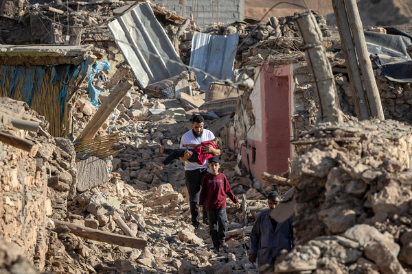 マラケシュの南西部にある村で、地震によって破壊された家屋のそばを歩く人たち。(モロッコ、2023年9月9日撮影/AFP)