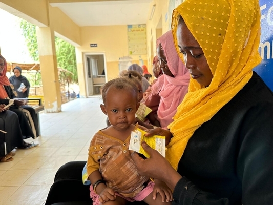 ポートスーダンの保健センターで、すぐに食べられる栄養治療食(RUTF)を口にする子ども。(スーダン、2023年9月13日撮影)