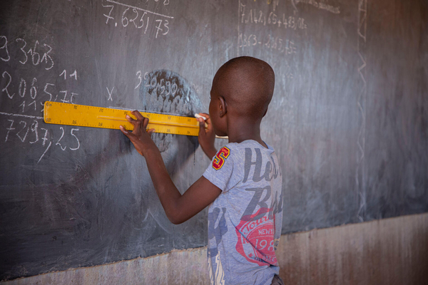 中北部地方のカヤの公立学校で、定規を使って黒板に計算式を書き込む子ども。(ブルキナファソ、2023年9月27日撮影)