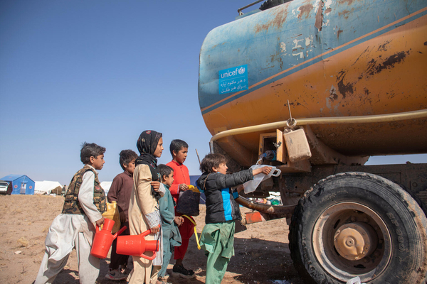 ユニセフの給水車から安全できれいな水を受け取る、地震で被災した子どもたち。(アフガニスタン、2023年10月10日撮影)