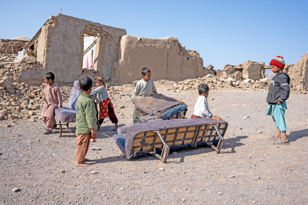 地震により倒壊した家から家具を運び出す子どもたち。(アフガニスタン、2023年10月14日撮影)
